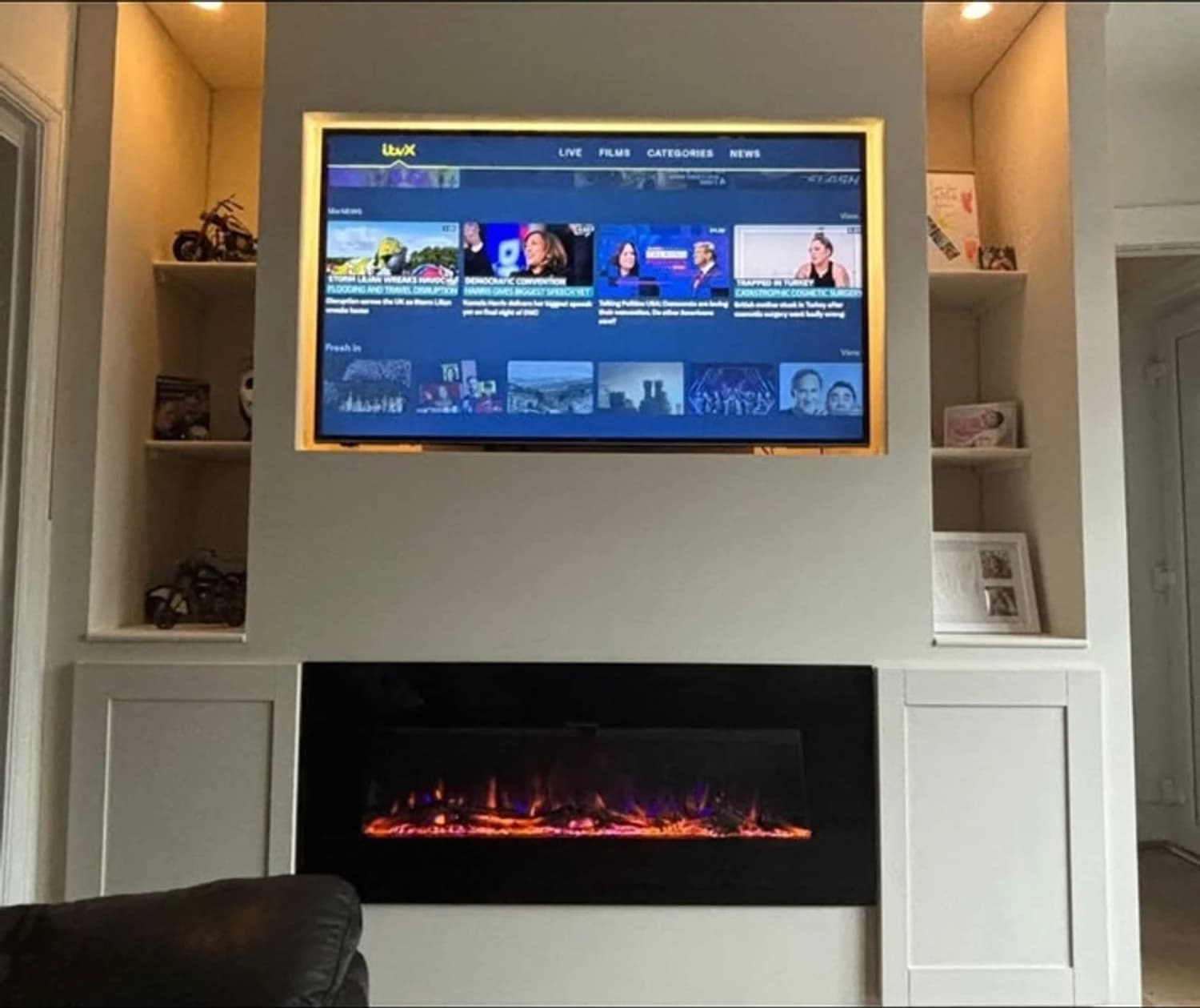 Built-in media wall with recessed TV, inset electric fire and display shelving