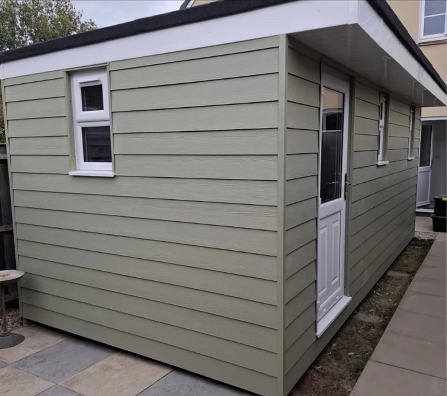 Timber-framed garden room with sage green cladding
